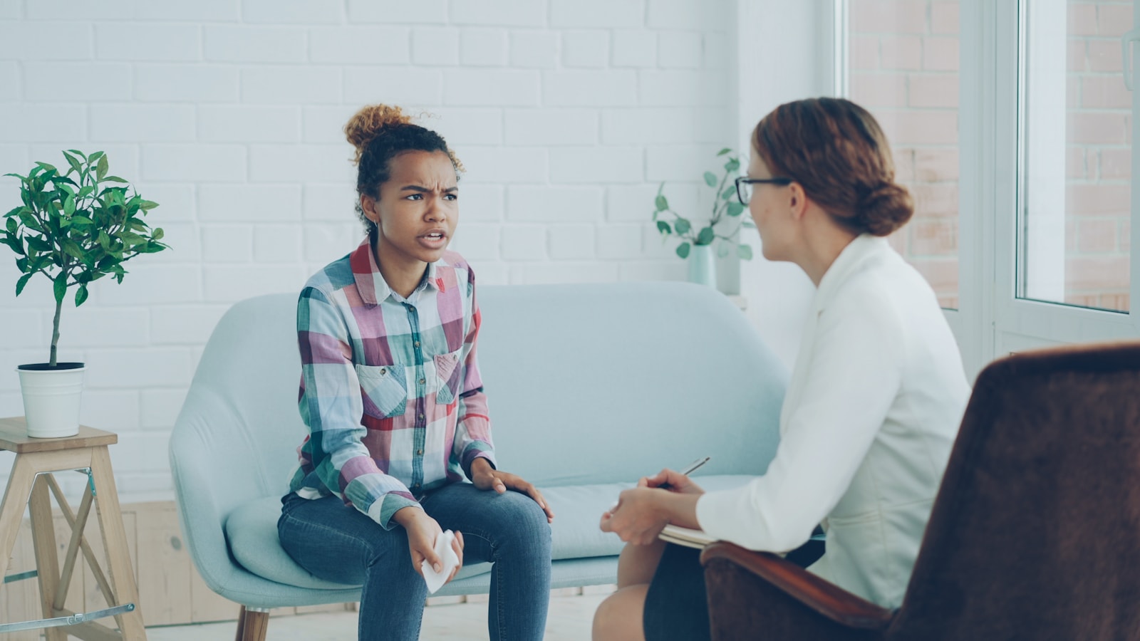 A therapist listening attentively while a client speaks during a session