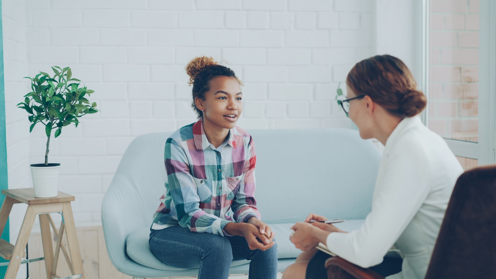 A therapist listening to a client during a session in a bright office